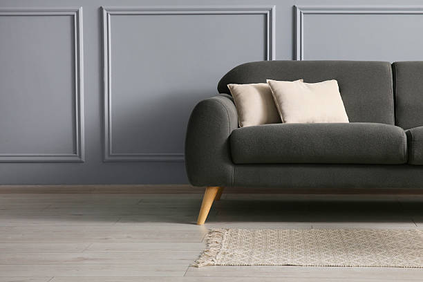 istock Stylish sofa with cushions near grey wall, space for text 2214772666