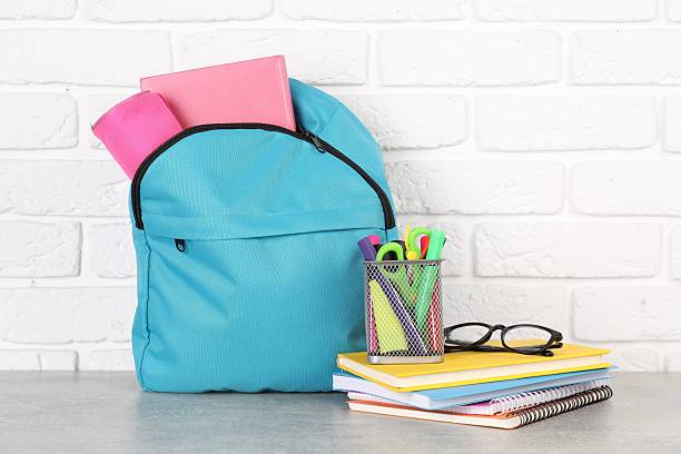 istock Backpack with different school stationery on light grey table near brick wall 2214773773