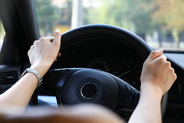 istock Woman holding steering wheel while driving car, closeup 2214774401
