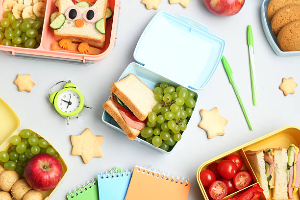 istock Lunch box with snacks, alarm clock and stationery on white background, flat lay 2214775350