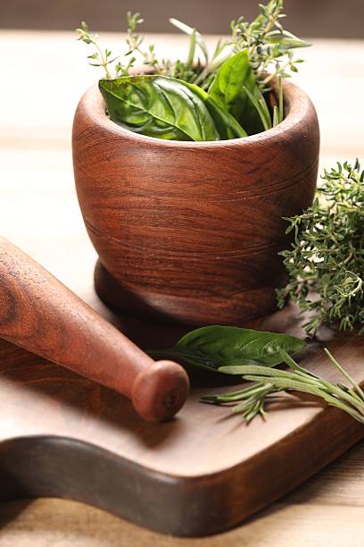 istock Different fresh herbs in mortar with pestle on wooden table 2214775589