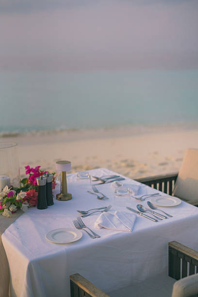 istock Table setting at restaurant on edge of sea 2214776743
