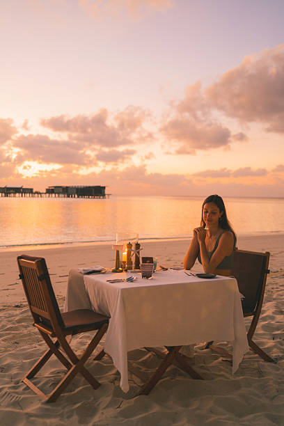 istock Young woman relaxes at beach cafe at sunset 2214776839