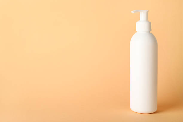 istock Shampoo in bottle on pale orange background, space for text 2214780586