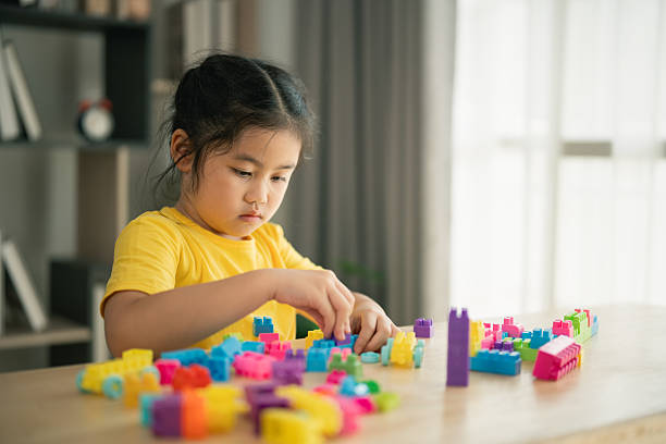istock Child Engaged in Creative Play with Colorful Building Blocks on a Bright Table, Promoting Imagination and Development in Early Childhood Learning 2214781053