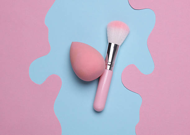 istock Makeup brush and sponge on blue pink paper cut creative background. Beauty concept 2214787501
