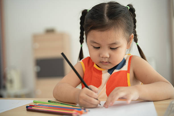 istock Young Girl Engaged in Creative Drawing Activity with Colored Pencils at Home, Focused on Artistic Expression and Imagination Development 2214790750