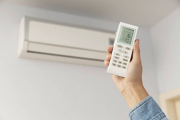 istock Female hand hold remote controller from air conditioner, space for text 2214791317