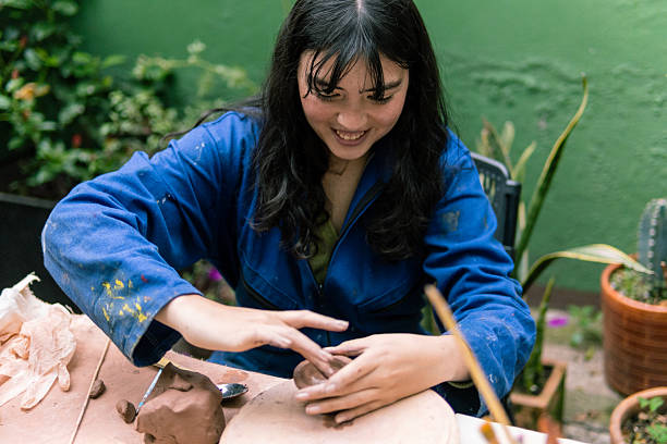 istock Young woman potter molding clay in her workshop 2214792918