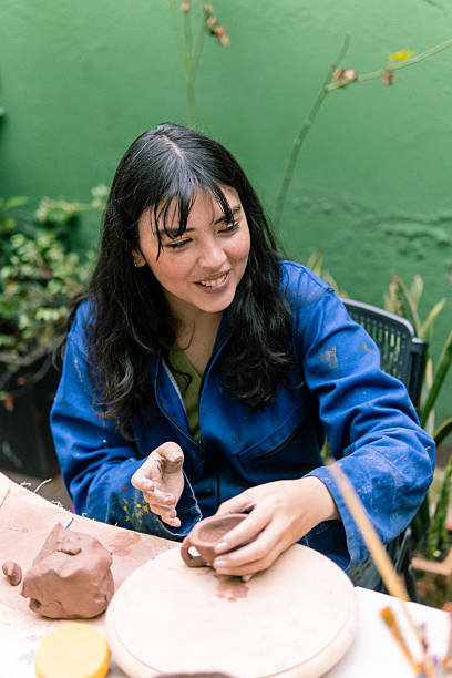 istock Potter creating small clay pot on wooden surface 2214793018