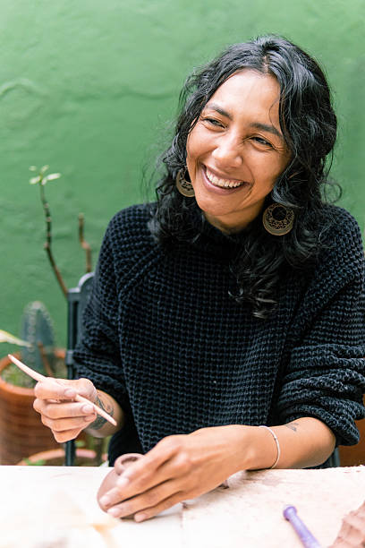 istock Smiling craftswoman working clay creating pottery in workshop 2214793616