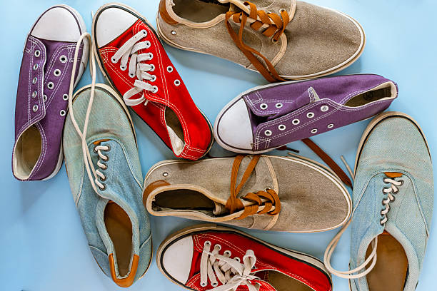 istock Worn sneakers of different colors and sizes on a blue background, top view. 2214794319