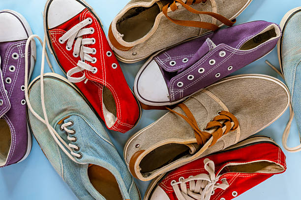 istock Worn sneakers of different colors and sizes on a blue background, top view. 2214794335