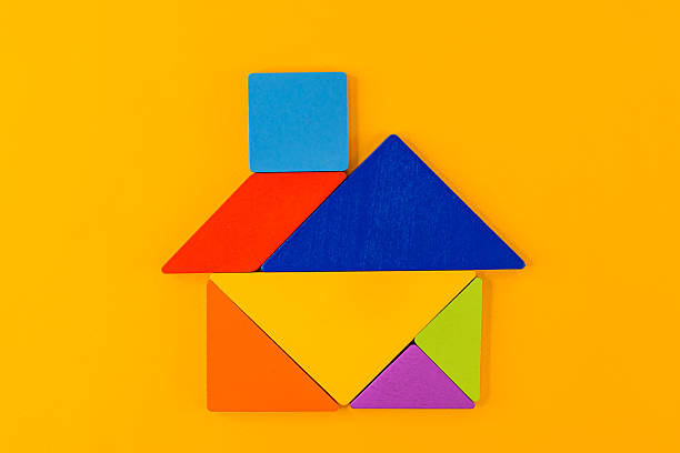 Tangram puzzle depicting a house on a yellow background, conceptual image