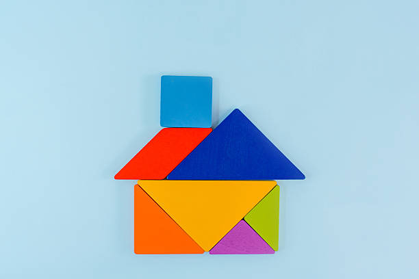 Tangram puzzle depicting a house on a blue background, conceptual image