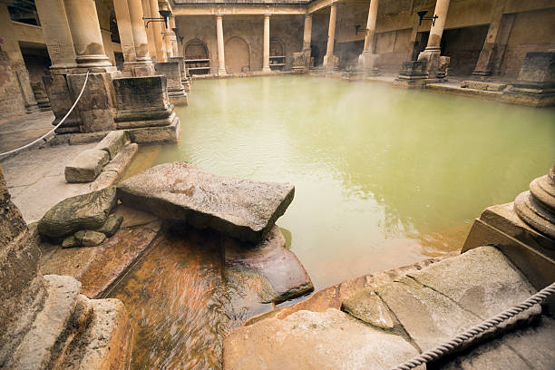 Bath, United Kingdom - June 4, 2014: Stone and columns around the steamy water at the Roman Bath in Bath England