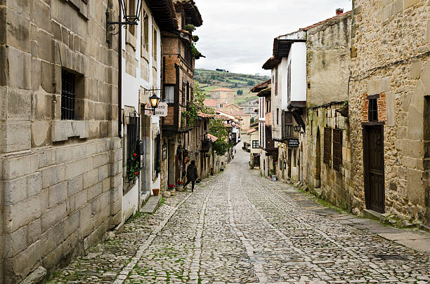 Santillana del Mar, Spain - January 27, 2013: A cobbled street in the old town of Santillana del Mar, Cantabria, Spain. At the back can be seen the Collegiate
