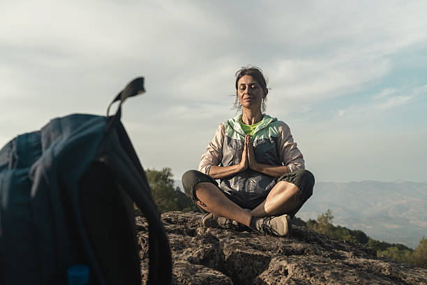 istock Woman meditating on mountain peak practicing mindfulness during hiking adventure 2214796955