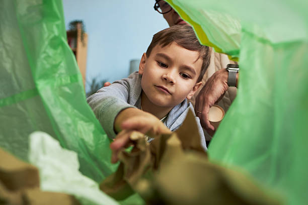 istock Little Boy Throwing Rubbish In Bin 2214800373