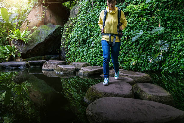 istock Female backpacker walking on stepping stones 2214801520