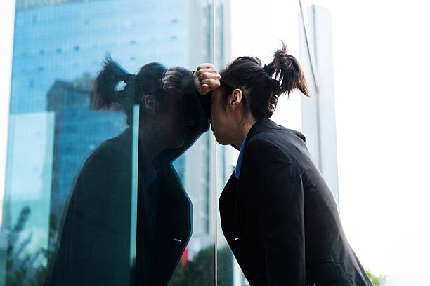 istock Businesswoman leaned her head against the wall 2214801640