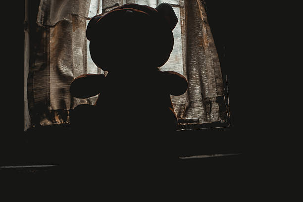 istock Silhouette of a Teddy Bear with Backlight in a Horror Atmosphere 2214805769