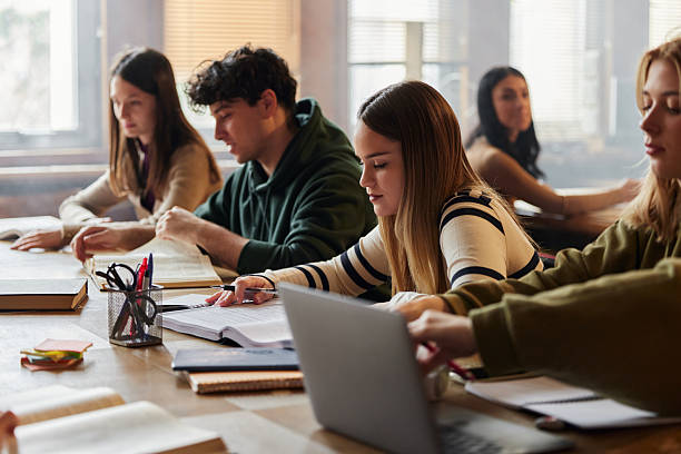 istock Young female student learning with her friends in library. 2214810148