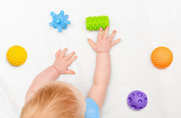 istock baby reaching for toys 2214810338