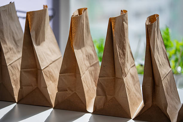 istock Brown paper grocery bags clustered on white surface, representing digital shopping convenience and efficient meal procurement for modern consumers 2214814712