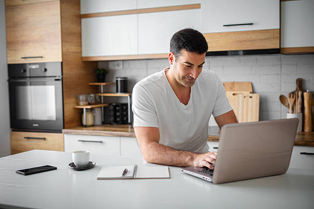 istock Man drinking coffee while working on his financial bills in kitchen 2214814748