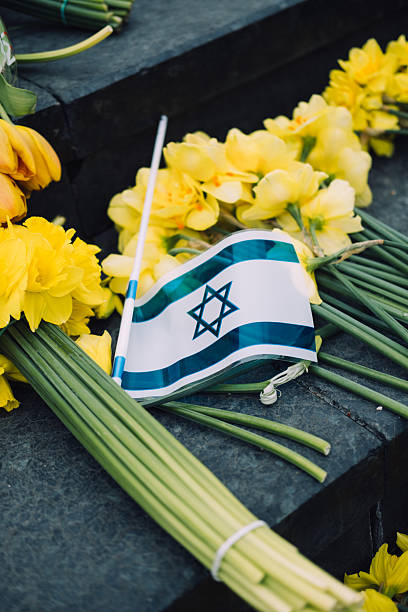 Israeli flag and yellow daffodils on stone steps, symbolizing Holocaust remembrance and national mourning