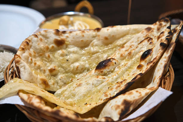 Close-up of freshly baked garlic naan in a basket.