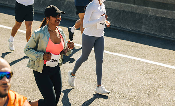istock Confident smiling female runner in a competitive race 2214816185