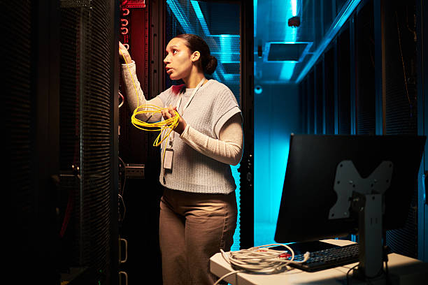 istock Woman Managing Server Room Equipment with Determination 2214816733