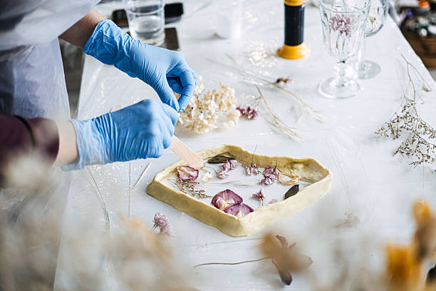 istock Hands arranging dried flowers into resin art piece, using sustainable materials for eco-friendly DIY home decor. Crafting with natural elements, focus on sustainability. 2214818054
