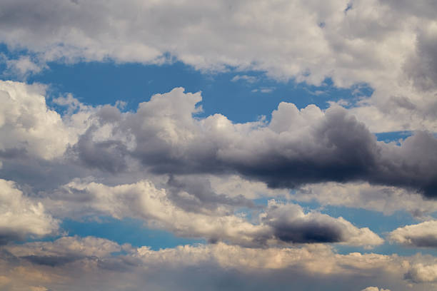 istock Cumulus clouds in the sky and sunlight on the clouds, cloudy background, clouds before a change in weather, light and dark edges of clouds in the sky. 2214822903