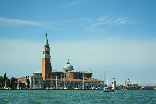 Scenic view of San Giorgio Maggiore island with historic architecture and a clear blue sky in Venice, Italy.