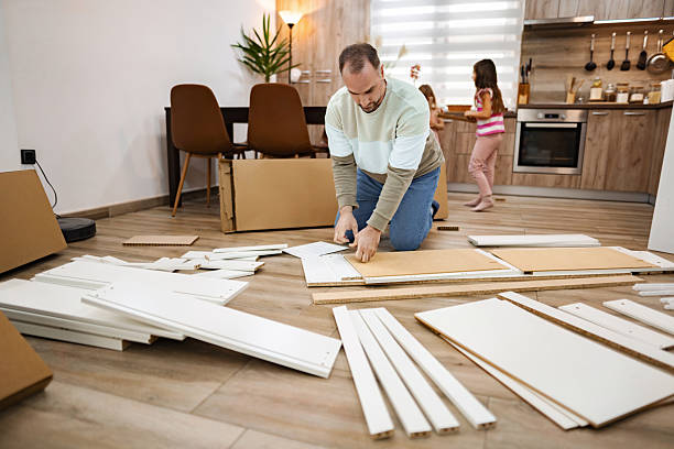istock Father assembling furniture while children playing in the kitchen 2214827030