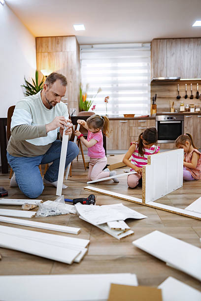 istock Father and daughters assembling furniture at home 2214827103