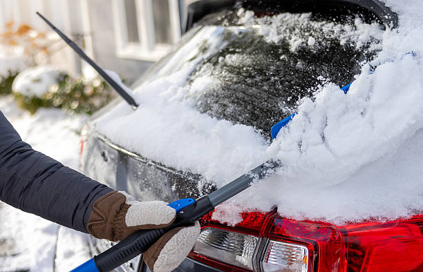 istock Woman Brushing Snow Off Rear Car Window 2214828212