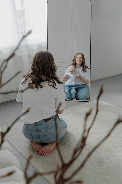 istock Mother with a child is reflected in the mirror in a bright apartment 2214828640