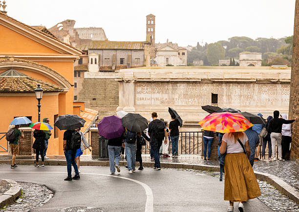istock People with umbrellas exploring city of Rome 2214828696