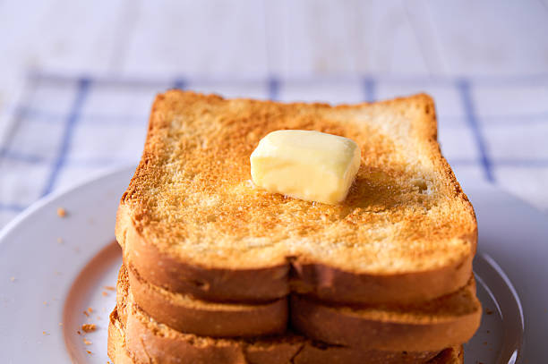 istock Butter melting on a crusty toasted bread on a wooden table, selective focus. 2214832698