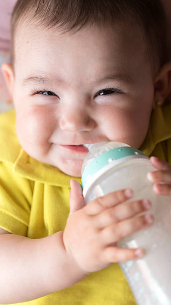 istock baby girl  drinks milk from a bottle 2214836338