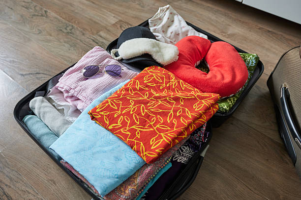 istock Open suitcase with clothes and accessories on the floor in the room. 2214837821