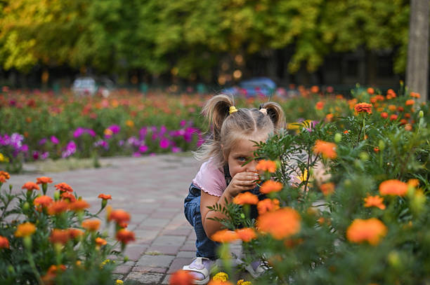 istock A little girl sniffs flowers on a walk 2214840437