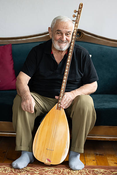 An elderly man performing turkish string instrument baglama