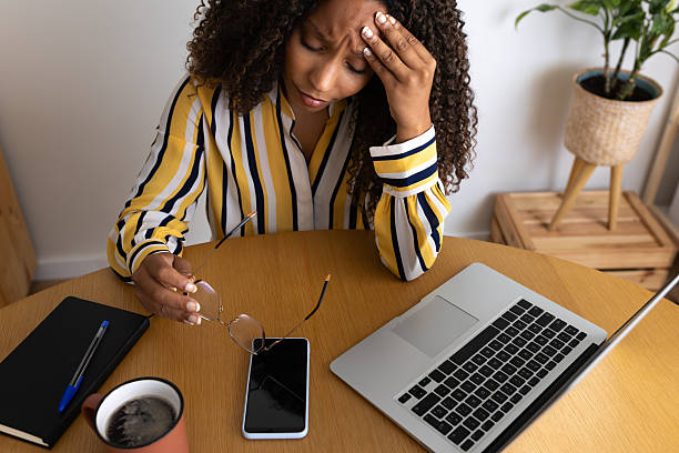 istock Stressed young woman having headache while working from home 2214843588