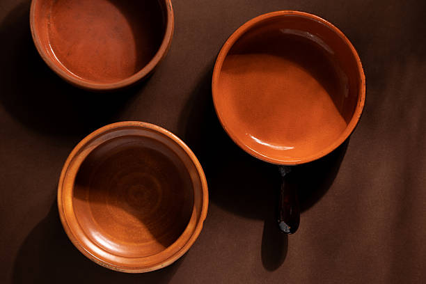 istock Arrangement of ceramic plates on brown background. Earthenware pottery objects, space for text. 2214844355