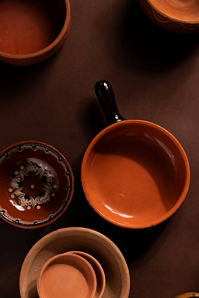 istock Arrangement of ceramic plates on brown background. Earthenware pottery objects, space for text. 2214844358